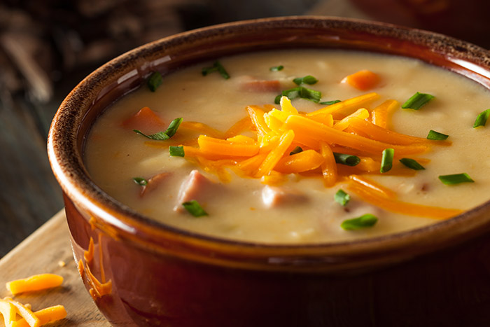 beer cheese soup with chives and shredded cheddar cheese