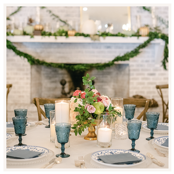 elegant table setting with blue and white china in front of a decorated fireplace mantel