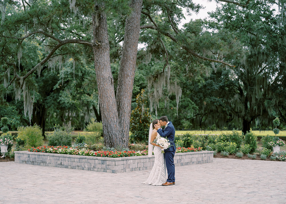 bride and groom standing in Cardinal Courtyard at Hewitt Oaks