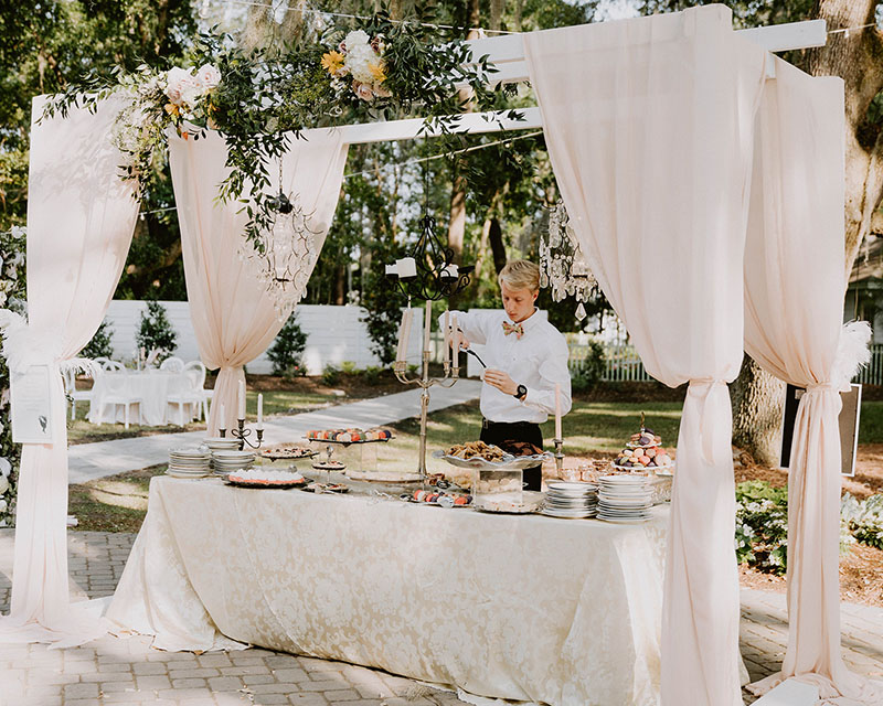 Server lights a candle at an elegant food station