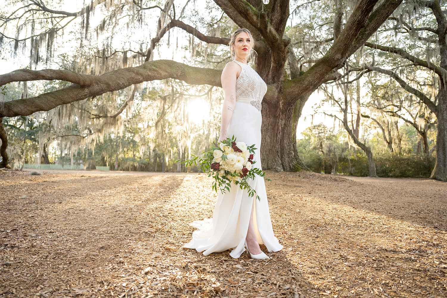 Bride holding wedding bouquet with a huge oak tree in the background