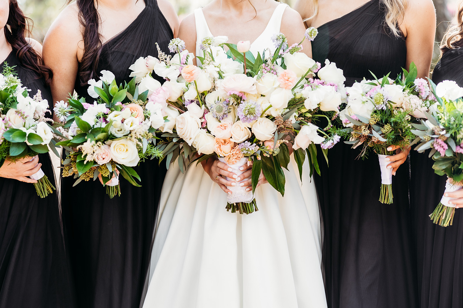 Bride and bridesmaids holding bouquets.