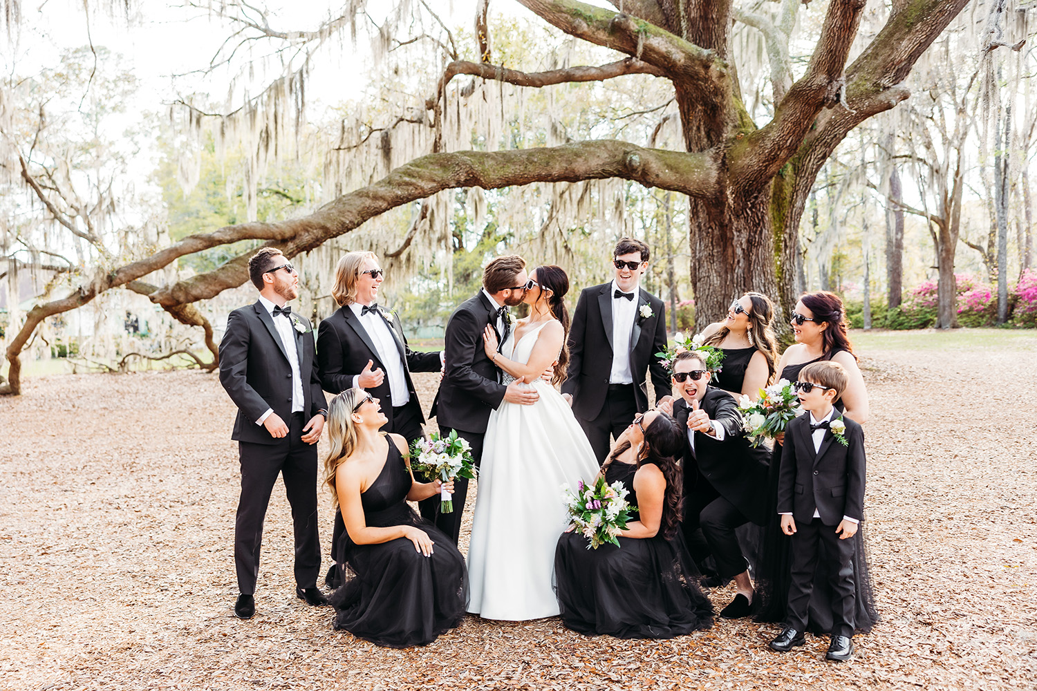 bride and groom kissing surrounded by bridesmaid and groomsmen.