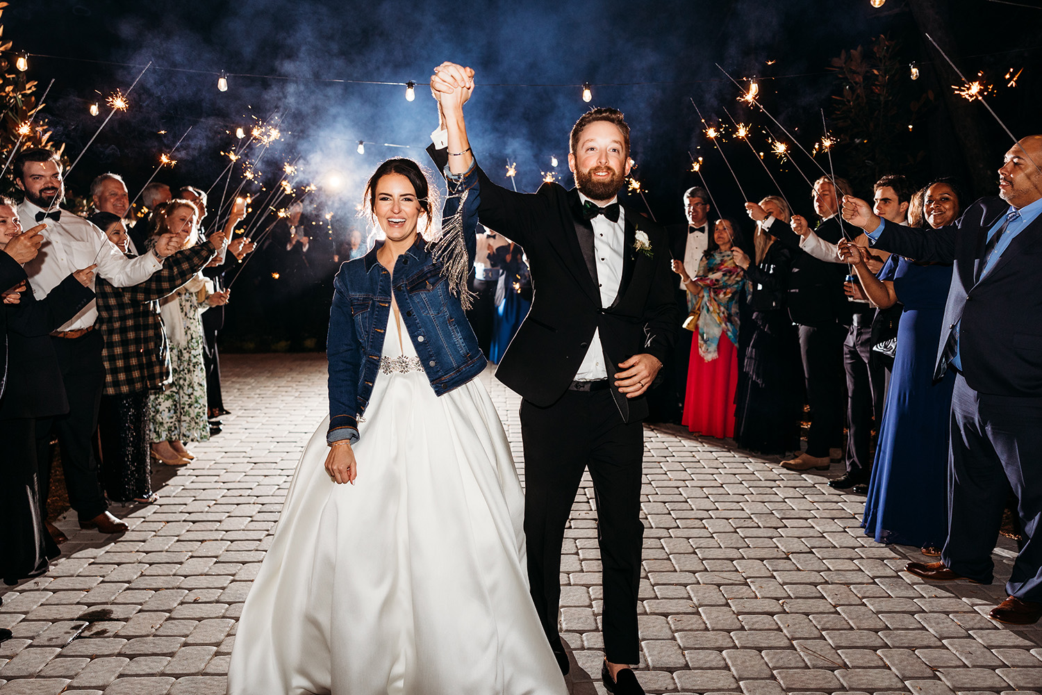 Bride and groom send-off with sparklers in the background.