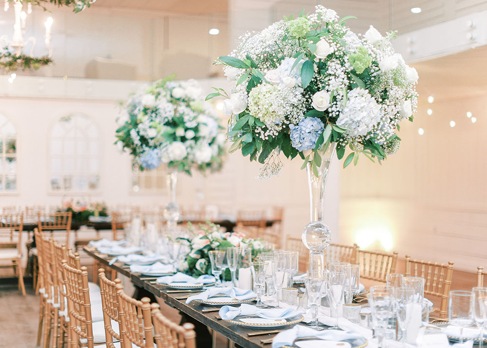 elegant tall floral arrangements with hydrangea and greenery in glass trumpet vases