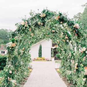 A decorative floral arch with a variety of colorful flowers.