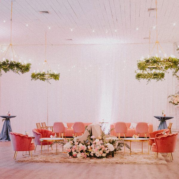 An indoor lounge with a pink theme, adorned with floral decorations.