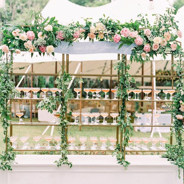 A decorative rack featuring an array of welcome cocktail drinks, adorned with floral designs.